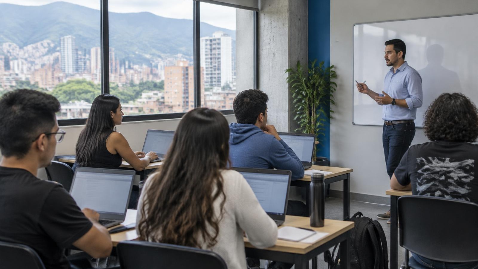 Aula de un instituto de formación en Medellín con estudiantes adultos trabajando en portátiles